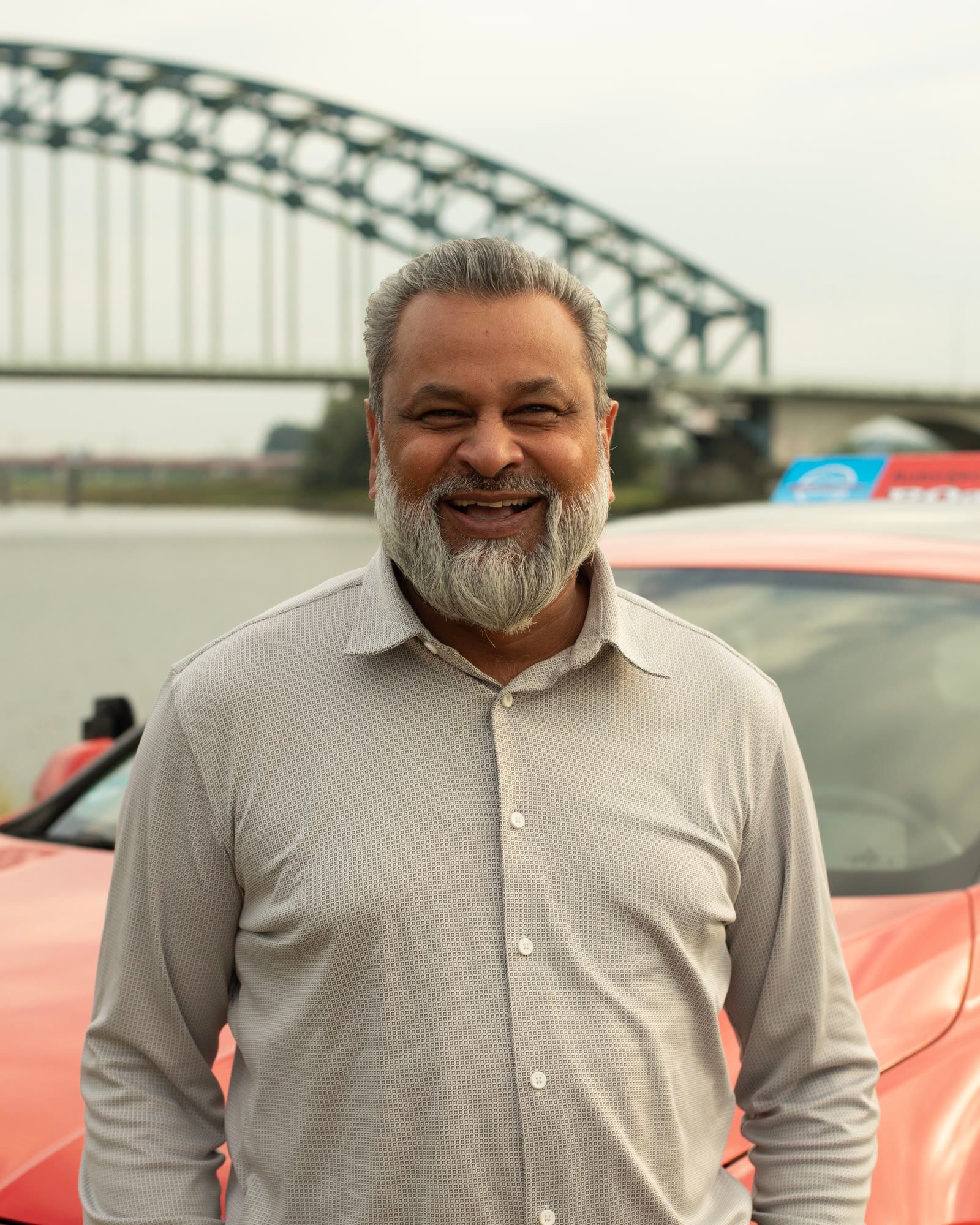 Ro, instructeur en eigenaar van ROadwise, lachend voor de lesauto